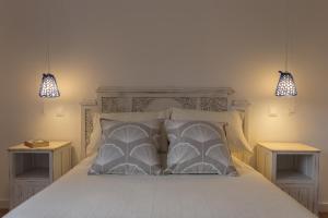 um quarto com uma cama branca com duas mesas de cabeceira em Lake View House em Sete Cidades