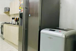 een koelkast in een keuken naast een aanrecht bij Apartamento de 4 Habitaciones Éxito de Laureles in Medellín
