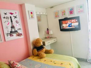 een teddybeer op een bed in een slaapkamer bij Apartamento de 4 Habitaciones Éxito de Laureles in Medellín