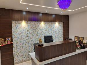 a reception desk in a lobby with a floral wall at Bouquet Residency in Nashik