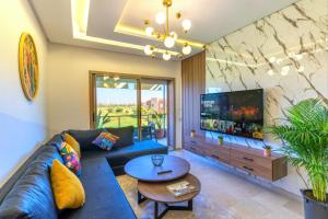 a living room with a blue couch and a tv at Cozy Golf Apartment Wifi 4k-TV Netflix in Marrakech