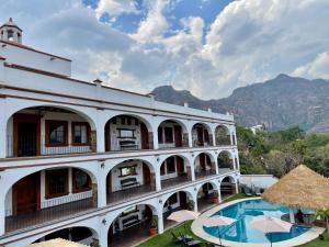 un edificio con piscina y montañas de fondo en Palacio Del Cobre, en Tepoztlán