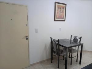 comedor con mesa, sillas y puerta en Moderno Apartamento Mendoza Céntrico en Mendoza