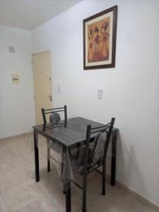 mesa de comedor con 2 sillas y una foto en la pared en Moderno Apartamento Mendoza Céntrico en Mendoza