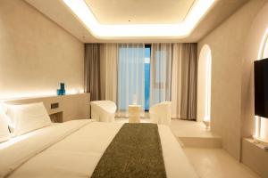a hotel room with a bed and a large window at Dream Designer Hotel - Huimin Street Branch of Xi'an Bell and Drum Tower in Xi'an