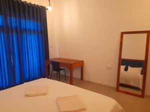 阿魯岡灣的住宿－Surf Gangs Arugambay，一间卧室配有一张床、一张书桌和一面镜子