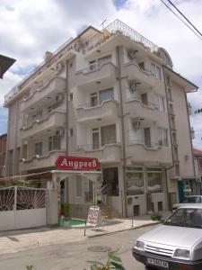 a large white building with a sign in front of it at Family Hotel Andreev in Nesebar