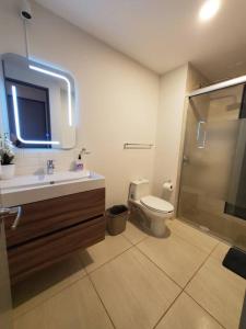 a bathroom with a toilet and a sink and a shower at Departamento Puesta del Sol Gdl in Guadalajara