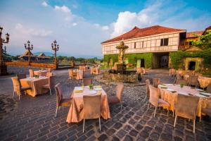 a restaurant with tables and chairs and a fountain at Las Casas Filipinas de Acuzar in Bagac