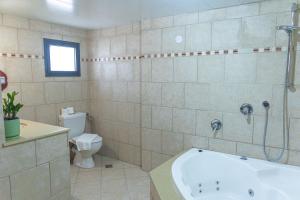 a bathroom with a tub and a toilet at Mantur Metula by Selina in Metulla