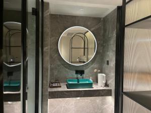 a bathroom with a sink and a mirror at Dream Designer Hotel - Huimin Street Branch of Xi'an Bell and Drum Tower in Xi'an