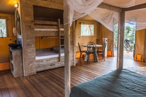 a bedroom with a bunk bed and a table at Glamping 148 Tasmania in St Helens