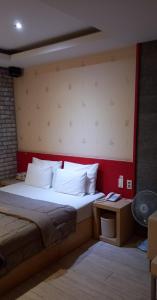 a bedroom with a large bed with a red wall at Design T Motel in Ulsan