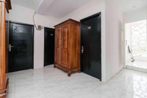 a room with a wooden cabinet and black doors at KoolKost Syariah near Bintaro Jaya Xchange in Peladen