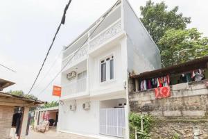 una casa blanca con ropa colgada en una pared en KoolKost Syariah near Bintaro Jaya Xchange en Peladen