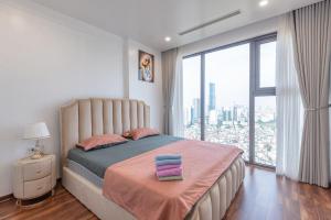 a bedroom with a bed and a large window at BOM HOMES-THE MATRIX ONE- LUXURY APARTMENT in Hanoi