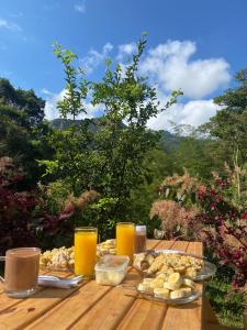 a table with food and glasses of orange juice at Colibamboo Domo Glamping in Pacho