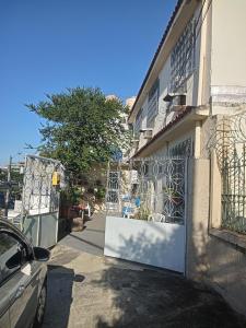 a building with a gate and a car parked next to it at Quartos Prox Engenhão e Norte Shopping in Rio de Janeiro