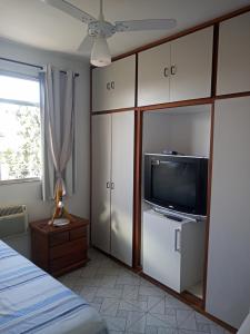 a bedroom with a television and white cabinets at Quartos Prox Engenhão e Norte Shopping in Rio de Janeiro