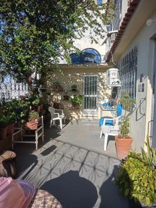 a patio with chairs and potted plants next to a building at Quartos Prox Engenhão e Norte Shopping in Rio de Janeiro