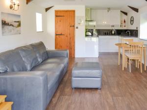 a living room with a couch and a table and a kitchen at Sunrise in St Austell