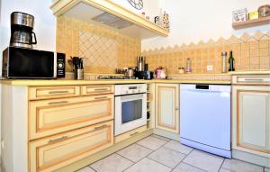 eine Küche mit Holzschränken und weißen Geräten in der Unterkunft Amazing Home In St Genies De Malgoires in Saint-Géniès-de-Malgoirès