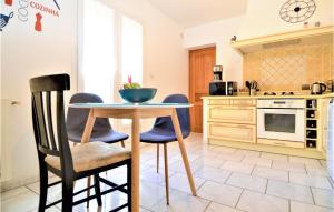 een keuken met een tafel en stoelen bij Cozy Home In St Genies De Malgoires With Ethernet Internet in Saint-Géniès-de-Malgoirès
