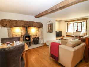 a living room with a couch and a fireplace at Castle Combe Cottage in Castle Combe