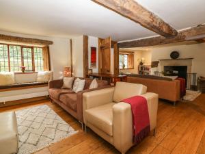 a living room with a couch and a chair at Castle Combe Cottage in Castle Combe