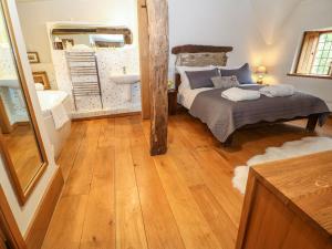 a bedroom with a bed and a sink and a mirror at Castle Combe Cottage in Castle Combe