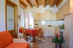 a kitchen with a table and chairs in a kitchen at Agritur de Poda Apartments in Flavon