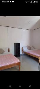 2 camas en una habitación con sábanas rosas en Mr.kwiiz inn, en Daanbantayan