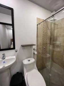 a bathroom with a toilet and a sink and a shower at Katara Boutique Hotel in Mariquita