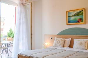 a bedroom with a bed and a table and a window at Agritur de Poda Apartments in Flavon