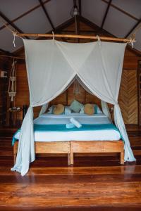 a bed with a canopy in a room at Soultribe Beach Retreat in General Luna