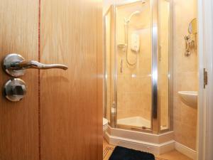 a bathroom with a shower and a glass door at Ocean Blue in Penzance +15 photos