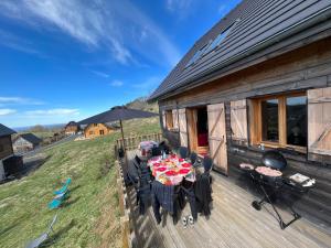 a patio with a table and chairs on a deck at Chalet des Monts Dore in Chastreix