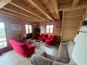 una sala de estar con muebles de color rojo en una casa de madera en Chalet des Monts Dore en Chastreix