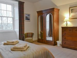 The Factors House - 25752 في Kilmartin: غرفة نوم بسرير وخزانة ومرآة