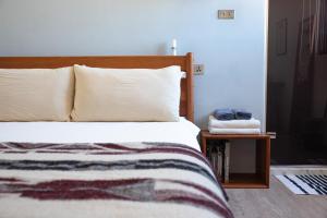 花蓮市的住宿－泊壹旅宿 (成人限定），卧室配有一张床,床头柜位于床边。