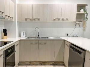 a kitchen with wooden cabinets and a sink at Trinity Links Resort in Cairns