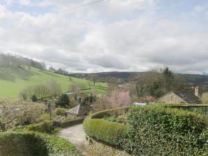 a winding road through a village with bushes at Bank Top Cottage in Hathersage