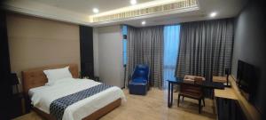 een slaapkamer met een bed, een bureau en een stoel bij NOMO Beijing Rd A Jiedeng Mix International Apartment in Guangzhou