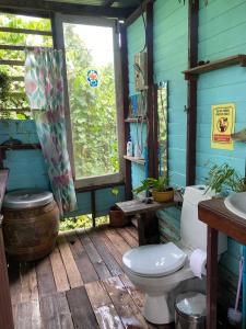 a bathroom with a toilet on a wooden deck at Baan GoLite Ko Kret - บ้านโกไล้เกาะเกร็ด in Nonthaburi