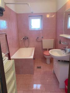 ein Badezimmer mit einer Badewanne, einem WC und einem Waschbecken in der Unterkunft Apartments Lado - 230 m from sea in Donje Selo