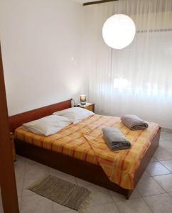 - une chambre avec un lit et 2 oreillers dans l'établissement Apartment Ivan - 15m from beach, à Vinišće