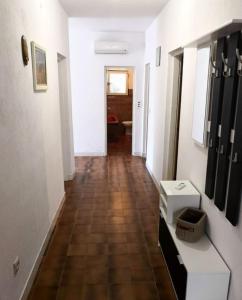 d'un couloir avec des murs blancs et du carrelage marron au sol. dans l'établissement Apartment Ivan - 15m from beach, à Vinišće