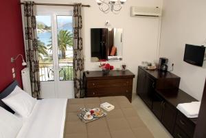 a hotel room with a bed and a table with a tray of food at Pension Hirolakas in Galaxidi