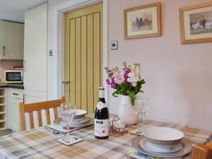 a table with a bottle of wine and glasses on it at Dairy Cottage in Matfield