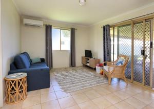 a living room with a blue couch and a chair at 13 Natalie Street Bargara in Bargara